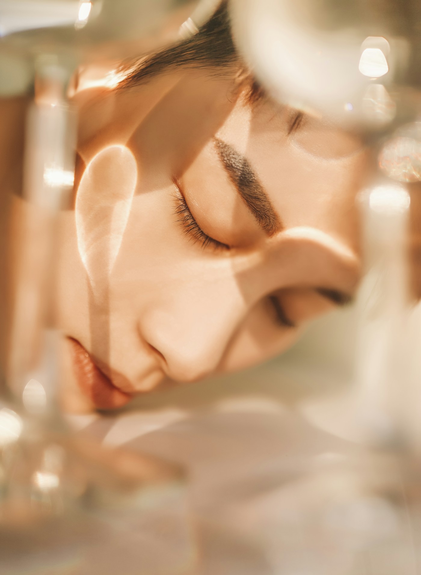 Skincare product held near fresh green leaves